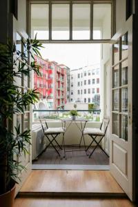 a balcony with a table and chairs and a window at Impar Studios in Porto