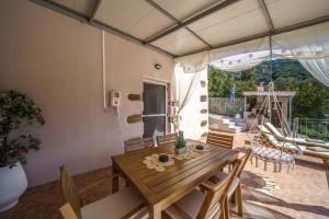 a dining room with a wooden table and chairs at Villa Koomas-Mountain View - kakodiki Paleochora in Avdhoulianá