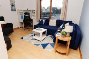 a living room with a blue couch and a table at Sound House, Shetland Islands in Lerwick +18 photos