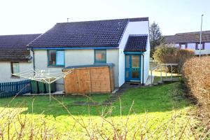 a white house with a blue door and a yard at Sound House, Shetland Islands in Lerwick
