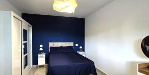 a blue bedroom with a bed and a blue wall at Apartamento Estilo Moderno in Belo Horizonte