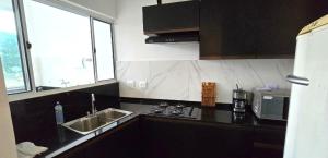 a kitchen with a sink and a microwave at Apartamento Estilo Moderno in Belo Horizonte