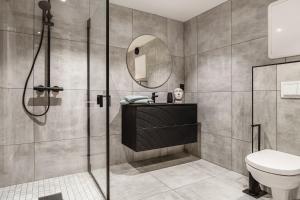a bathroom with a shower and a sink and a toilet at Trolltunga Fjords in Tokheim +8 photos