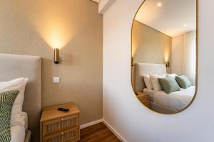 a bedroom with a mirror next to a bed at Douro View Charming Apartment Duplex in Valbom
