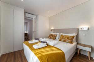 a bedroom with a large bed with towels on it at Douro View Charming Apartment Duplex in Valbom +37 photos