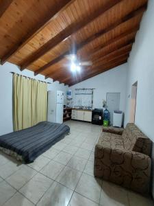 a bedroom with a bed and a couch in a room at Cabaña la Gabita in Villa Ciudad Parque