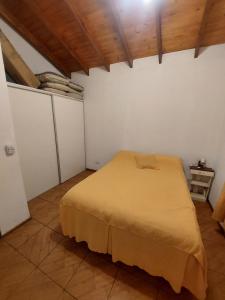 a bedroom with a bed in a room with wooden ceilings at Cabaña la Gabita in Villa Ciudad Parque