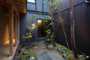 a garden in front of a house with trees at Masarigusa Machiya House in Kyoto