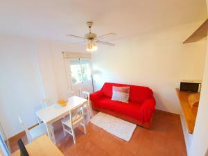 a living room with a red couch and a table at APARTAMENTO PALS BEACH-3 in Pals