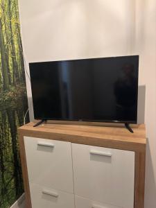 a flat screen tv sitting on top of a dresser at Apartamenty Stacja in Reszel