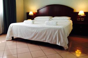 a bedroom with a large bed with white sheets and pillows at venice blu hotel in Mirano