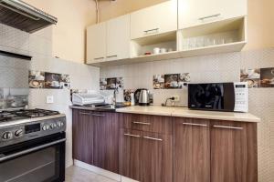 a kitchen with wooden cabinets and a microwave at Comfort Forum House in Lviv