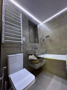 a bathroom with a toilet and a sink and a tub at Comfort Forum House in Lviv