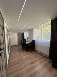 a dining room with a table and chairs and a window at Comfort Forum House in Lviv