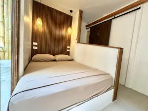 a small bed in a room with a window at Kalunay Hostel - Breakfast included in Puerto Viejo +51 photos
