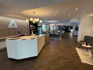a lobby with a white counter and some chairs at Hotel Alpha in Fribourg