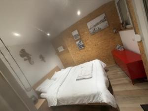 a bedroom with a white bed and a red cabinet at Un écrin chic à deux pas de la mer in Merlimont