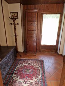 a room with a dresser and a door with a rug at maso denis in Canale San Bovo