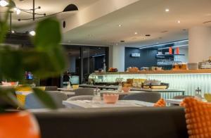 a restaurant with tables and chairs and a counter at Hotel Alpha in Fribourg