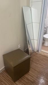 a stool in a bathroom with a mirror and a toilet at Na Ladeira Studio 06 in Rio de Janeiro