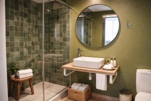 a bathroom with a sink and a shower with a mirror at Aparthotel Montcada in Montcada i Reixac