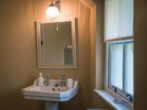 a bathroom with a sink and a mirror and a window at Killee Cottage in Mitchelstown