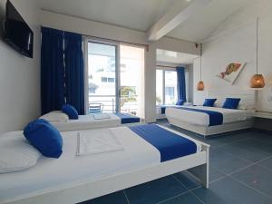 a bedroom with two beds and a large window at Hotel Portoalegre in Coveñas