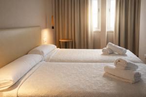 a hotel room with two beds with towels on them at Aparthotel Montcada in Montcada i Reixac