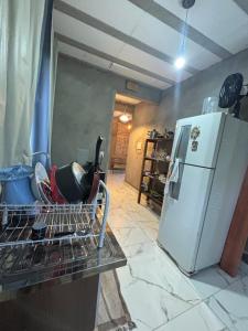 a kitchen with a dish drying rack next to a refrigerator at Chalé Florada d' Serra in Chapada dos Guimarães +44 photos