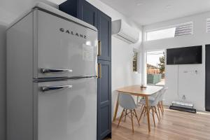 a kitchen with a refrigerator and a table with chairs at Spacious w/ 2BR 2Bath - Big Bear in Big Bear City