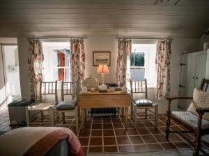 a room with a table and chairs and windows at Killee Cottage in Mitchelstown +23 photos