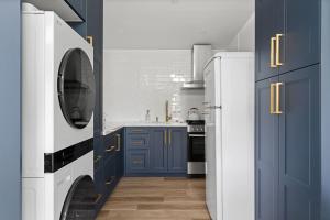 a kitchen with blue cabinets and a washer and dryer at Spacious w/ 2BR 2Bath - Big Bear in Big Bear City +3 photos