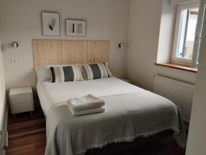 a bedroom with a bed with two towels on it at Casa Gaztelu Txiki in Irún