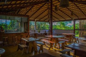 a restaurant with wooden tables and chairs and windows at Chalés Terraviva in Pirenópolis