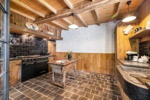 a kitchen with wooden walls and a wooden table at Casiola - Authentic vacation home 'De Blauwe Kroon' in Oostkamp