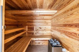 a wooden sauna with a bench in the middle at Casiola - Authentic vacation home 'De Blauwe Kroon' in Oostkamp +21 photos