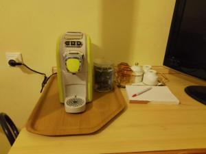 eine Kaffeemaschine auf einem Holztablett auf einem Schreibtisch in der Unterkunft Volano in Lido di Volano