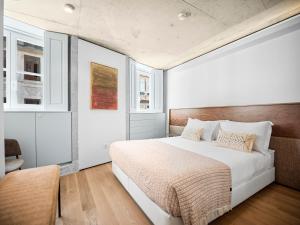 a bedroom with a large bed and two windows at Padrão 319 - Touristic Apartments in Porto