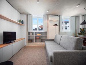 a living room with a couch and a television at Padrão 319 - Touristic Apartments in Porto