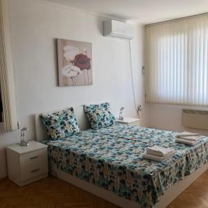 a bedroom with a bed with a floral bedspread at Villa Rocky in Sozopol +28 photos