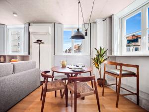 a living room with a table and chairs and a couch at Padrão 319 - Touristic Apartments in Porto