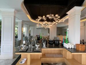 a kitchen with a table and a chandelier at Grand Eska Hotel & Suites Batam in Nagoya