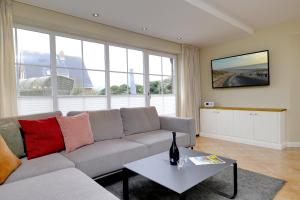 a living room with a couch and a table at Friesenjung in Wenningstedt