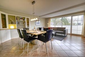 a dining room and living room with a table and chairs at Friesenjung in Wenningstedt
