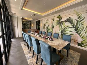 a conference room with a long table and blue chairs at Grand Eska Hotel & Suites Batam in Nagoya