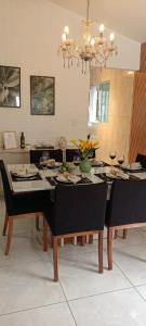 a dining room with a table with chairs and a chandelier at Garden JP in João Pessoa