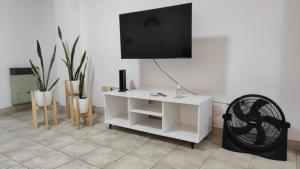 a living room with a tv and a white desk at Departamento La Merced in Santiago del Estero