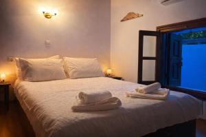 a bedroom with a bed with towels on it at Aegean soul apartments in Halki