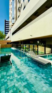 a swimming pool with a slide in a building at Studio Desing 3 - Lions Maceió in Maceió