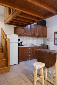a kitchen with wooden cabinets and a white refrigerator at Aegean soul apartments in Halki